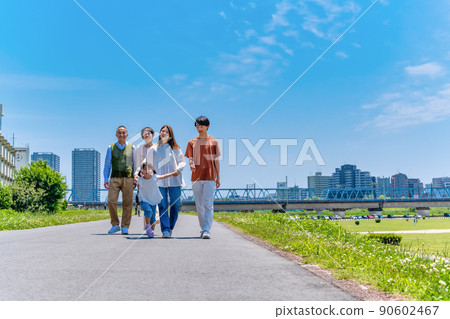 Three generations of a close family walking along the riverbed 90602467