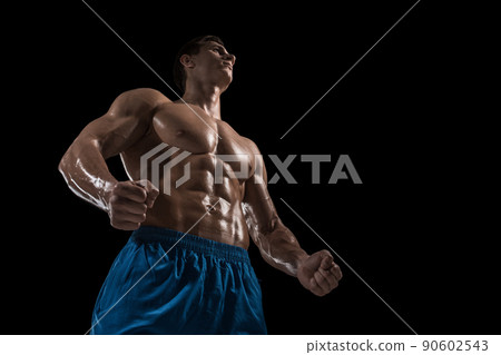 Muscular and fit young bodybuilder fitness male model posing over black background. Muscular and fit young bodybuilder fitness male model posing over black background. 90602543