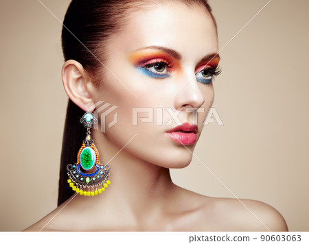 Portrait of beautiful young woman with earring. Jewelry and accessories 90603063