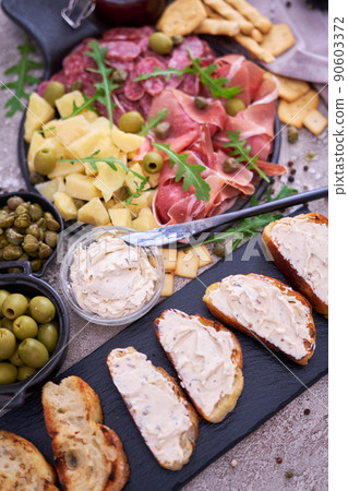 Bread with cheese and Italian antipasto meat platter - prosciutto ham, bresaola, salami and parmesan 90603372