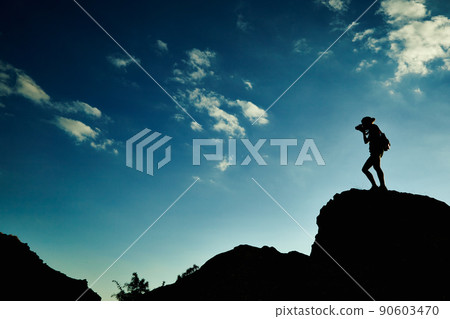 Woman silhouette at sunset in mountains 90603470