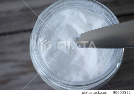 Glass bowl with baking soda, soda on the tip of a knife on a wooden background. Glass bowl with baking soda, soda on the tip of a knife on a wooden background. 90603552