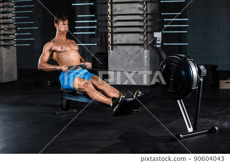 Muscular man doing exercise for legs in the gym 90604043