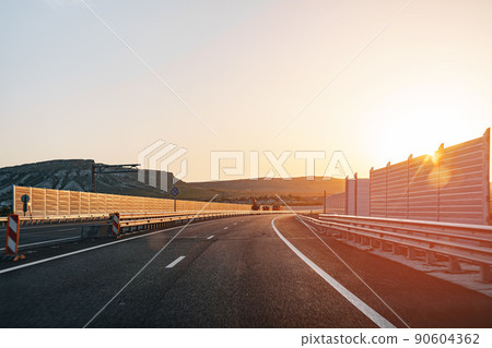 Empty highway at dawn, view from driver's perspective Empty highway at dawn, view from driver's perspective 90604362