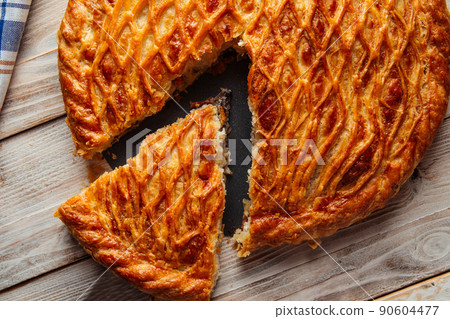 Sliced baked meat pie on wooden plate 90604477