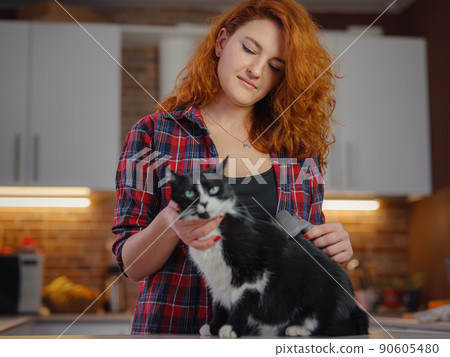 woman cat grooming at home 90605480