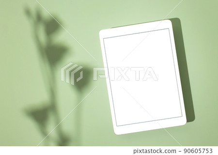 Blank screen tablet mock up and shadow on green pastel background. Copy space. Mock up template. Business communication. Isolated object. Spring decoration. 90605753
