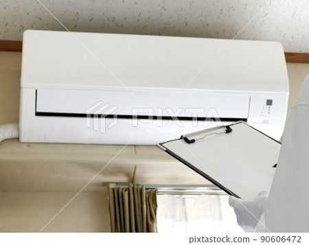 Hands of white gloves with a clipboard to assess the air conditioner Hands of white gloves with a clipboard to assess the air conditioner 90606472