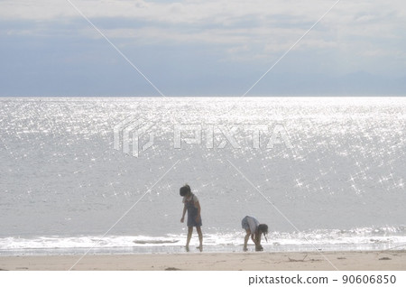 Girls playing in the glittering sea 90606850