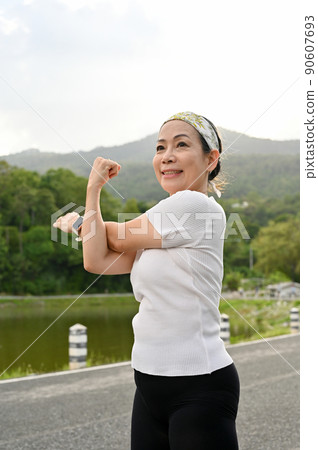 Happy healthy asian aged woman in a sportswear stretching her arms Happy healthy asian aged woman in a sportswear stretching her arms 90607693