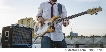 Bass player playing outdoors in a festival Bass player playing outdoors in a festival 90607700