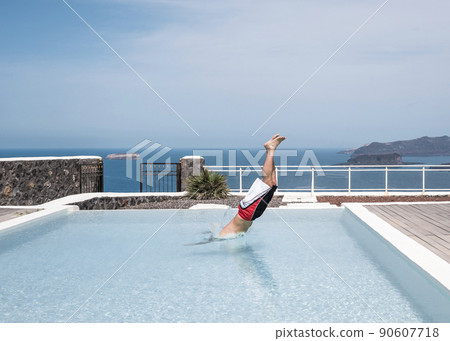 Man diving into a swimming pool in a resort 90607718