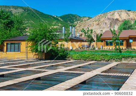 fish farm in a mountain valley with aquaculture cages and wooden buildings 90608832