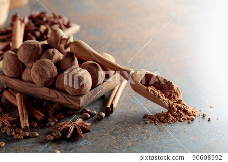Chocolate truffles and spoon with cocoa powder. 90608992