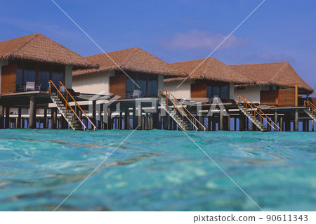 Water View to the Ocean Villas on the Maldives with the Natural Roofs and Clear Blue Waves 90611343