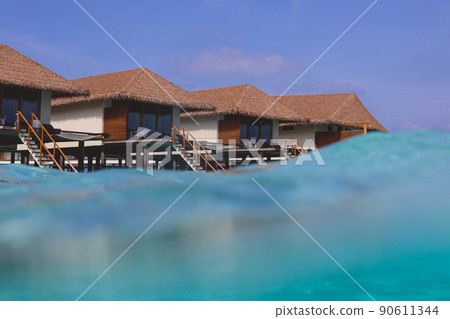 Water View to the Ocean Villas on the Maldives with the Natural Roofs and Clear Blue Waves 90611344