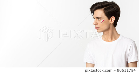 People, lgbtq community and lifestyle concept. Profile view of handsome gay man with glitter on face, looking left, standing over white background People, lgbtq community and lifestyle concept. Profile view of handsome gay man with glitter on face, looking left, standing over white background 90611784