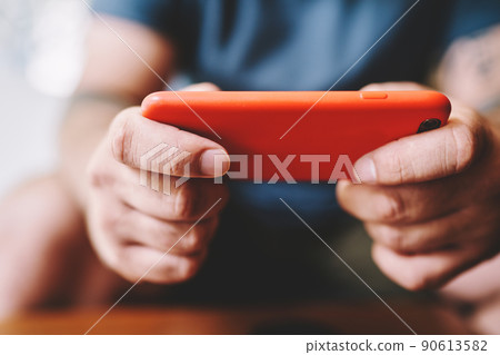 Man playing game on smartphone online Man playing game on smartphone online 90613582