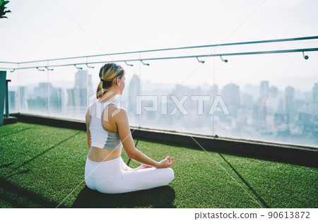 Woman practicing yoga on green roof Woman practicing yoga on green roof 90613872