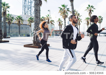 Experienced runners in sportive wear enjoying morning cardio exercising during crossfit practice 90614944