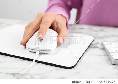 Woman using modern wired optical mouse at office table, closeup 90615032