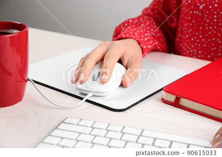 Woman using modern wired optical mouse at office table, closeup 90615033