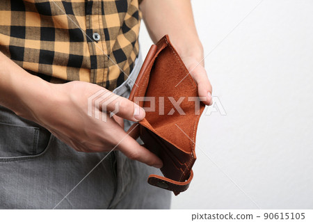 Man showing empty wallet on light background, closeup Man showing empty wallet on light background, closeup 90615105