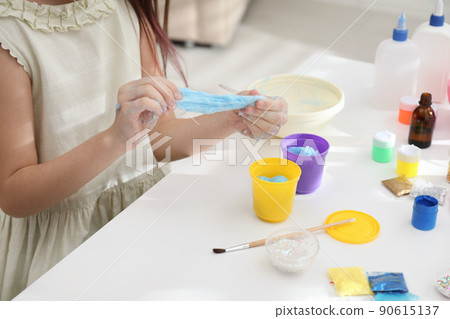Little girl making DIY slime toy at table, closeup Little girl making DIY slime toy at table, closeup 90615137