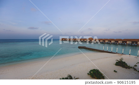 Sunset View to the Luxury Water Villas among Clear Blue Water with White Sand in the Heart of Indian Ocean, Maldives 90615195