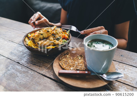 Female sitting in cafe and eating tasty food 90615200