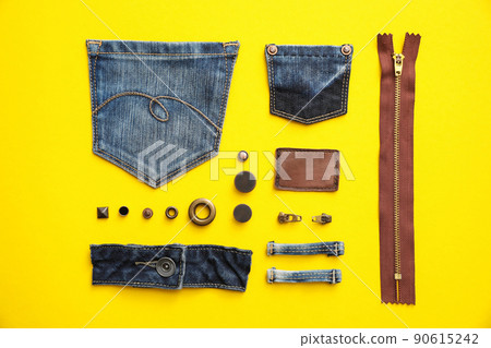 Flat lay composition with garment accessories and cutting details for jeans on yellow background Flat lay composition with garment accessories and cutting details for jeans on yellow background 90615242
