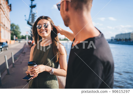 Happy diverse tourists in trendy sunglasses discussing travel plan and laughing 90615297