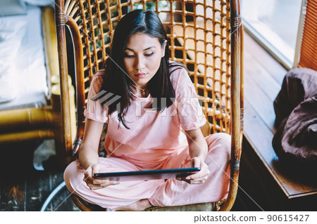 Millennial woman with touch pad technology checking received messages 90615427