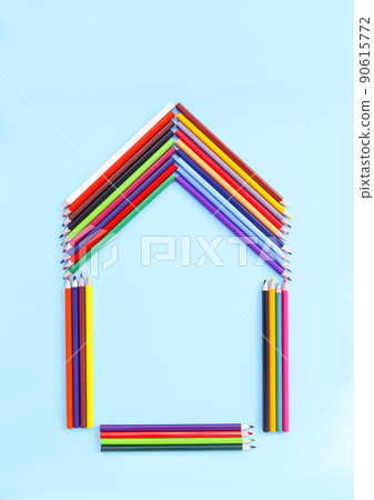 Color pencils in a shape of house on light blue background. 90615772