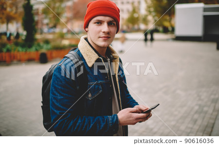Calm man messaging on smartphone while walking 90616036