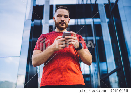 Serious man messaging on smartphone in downtown Serious man messaging on smartphone in downtown 90616486