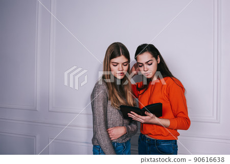Young students reading book together while doing homework 90616638