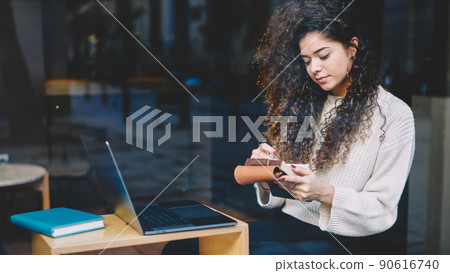 Skilled female student holding education textbook checking informative notes Skilled female student holding education textbook checking informative notes 90616740