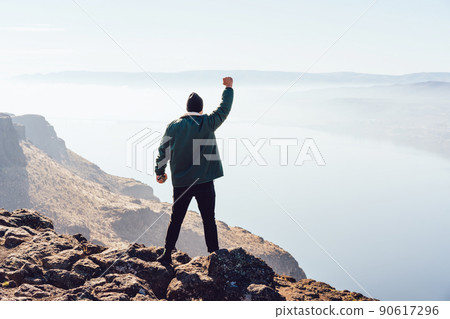 Unrecognizable man enjoying success of raising on mountain Unrecognizable man enjoying success of raising on mountain 90617296