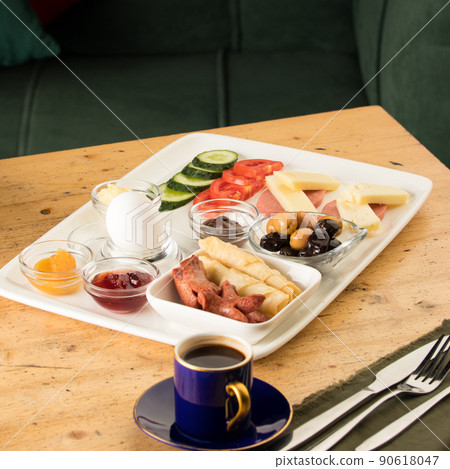 Closeup shot of a breakfast white plate and a cup of coffee on a wooden table 90618047