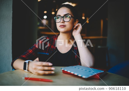 Pensive ethnic lady using smartphone for work in cafe 90618110