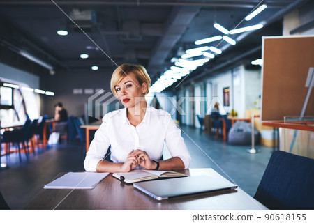 Serious woman with notepad in modern workplace Serious woman with notepad in modern workplace 90618155