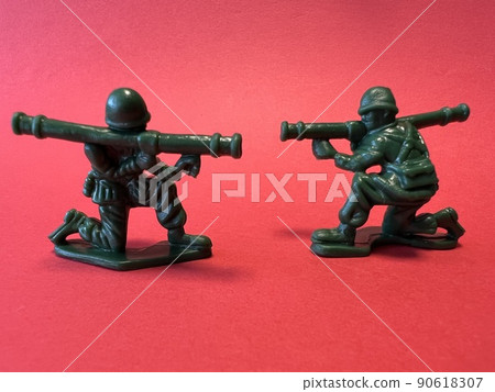 Doll-shaped (red background) of two soldiers holding guns, image of war Doll-shaped (red background) of two soldiers holding guns, image of war 90618307