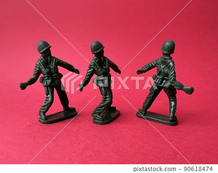 Three soldier dolls throwing grenades (red background), war and terrorist images 90618474