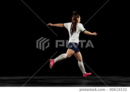 Back view of energetic soccer, football player running isolated on dark background. Sport, action, competitions, games and fitness concept 90619132