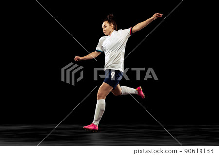 One caucasian energetic woman, soccer, football player in motion isolated on dark background. Sport, action, competitions, games and fitness concept One caucasian energetic woman, soccer, football player in motion isolated on dark background. Sport, action, competitions, games and fitness concept 90619133