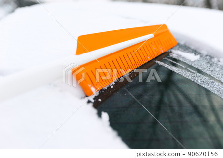 Cleaning snow from a car window Cleaning snow from a car window 90620156