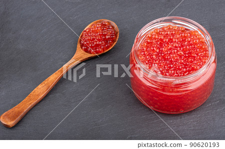 Glass jar and wooden spoon with red caviar. Glass jar and wooden spoon with red caviar. 90620193