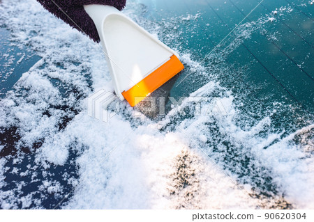 Cleaning car glass from ice with a scraper Cleaning car glass from ice with a scraper 90620304