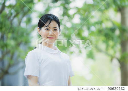 Woman in a white coat outdoors 90620682